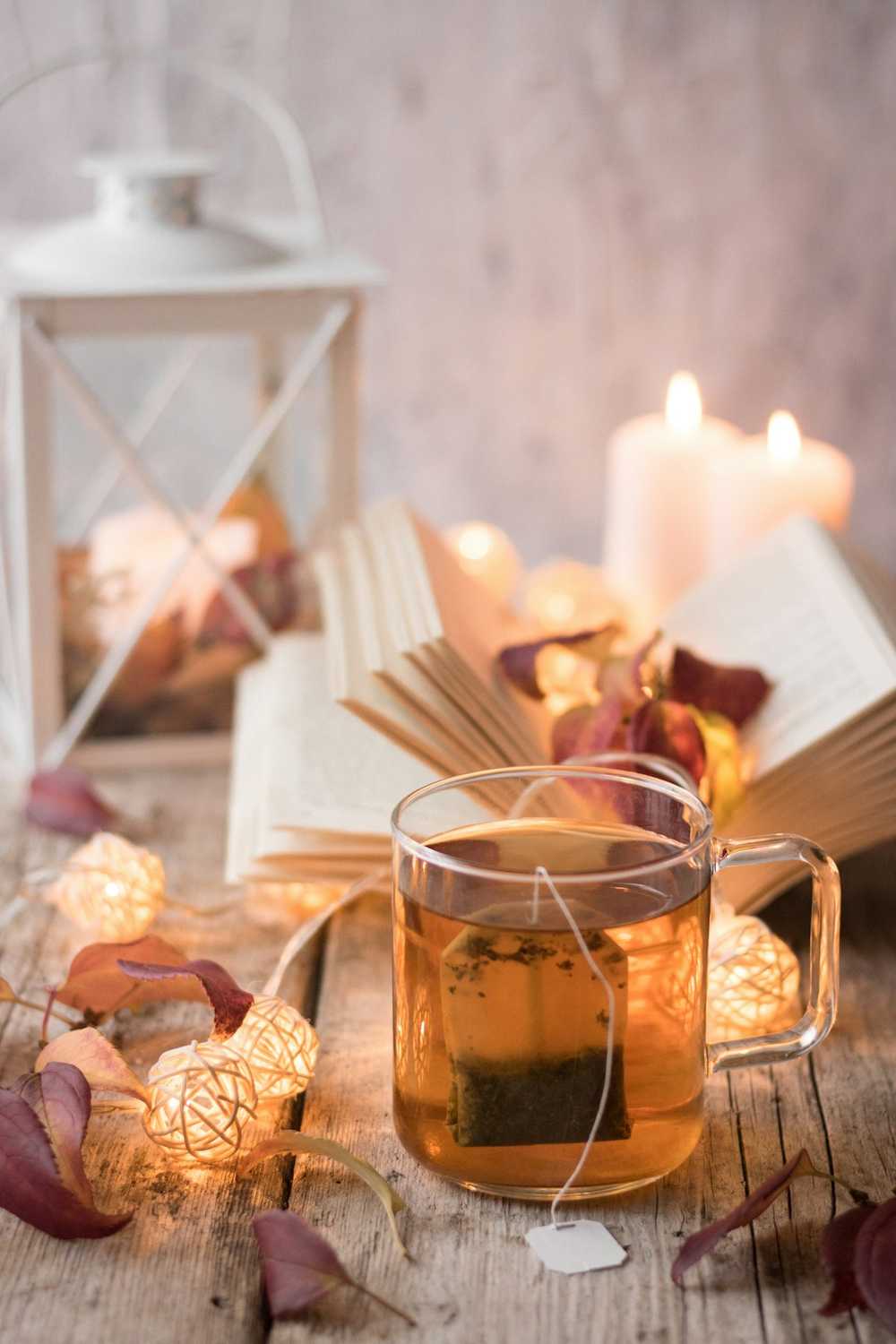Chén trà trên bàn gỗ, ánh nến ấm (ảnh mẫu)